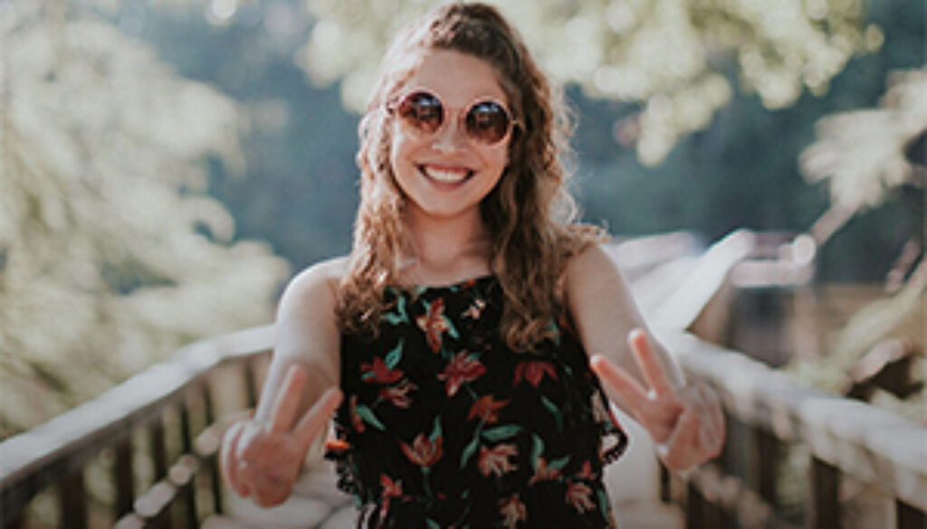 young successful woman pointing V for Victory fingers
